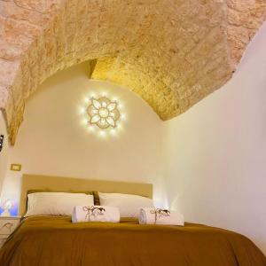 奥斯图尼Dimora Le Volte Ostuni的一间卧室设有一张带石质天花板的大床