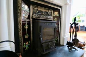 格拉斯哥Two Bed Holiday Home in Glasgow的客房设有壁炉,配有电视。