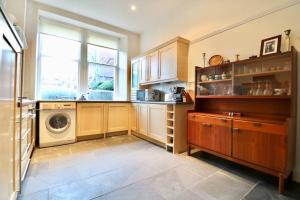 格拉斯哥Two Bed Holiday Home in Glasgow的厨房配有洗衣机和窗户。