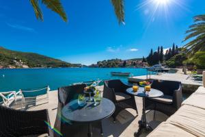 扎通Adria House Dubrovnik by the sea的一个带桌椅的庭院,毗邻水域