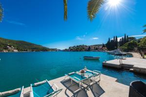 扎通Adria House Dubrovnik by the sea的湖上一组椅子和一张桌子