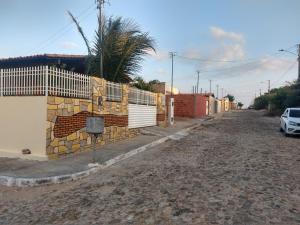 巴纳伊巴Sua casa no litoral的一条有栅栏和棕榈树的空街道