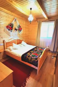 马里瑟尔Cabanele FloriCrin - Cabana Mare的木制客房内的一间卧室,配有一张床
