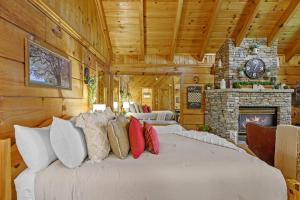 鸽子谷Do Not Disturb - Pigeon Forge Smoky Mountain Studio Cabin, Hot Tub, Fireplace的带壁炉的客房内的一张大床