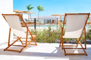 Parque HolandesShambhala Fuerteventura的庭院设有两把躺椅和游泳池