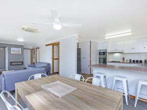 仙女港Eastern Beach Unit 7的客厅以及带木桌和椅子的厨房。