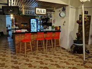 阿普洛Club campestre el Peñón de Apulo的餐厅内带红色酒吧凳的酒吧
