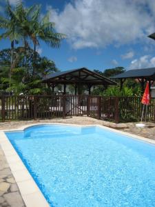 Matoury马尔莫特酒店的一个带木栅栏和遮阳伞的游泳池
