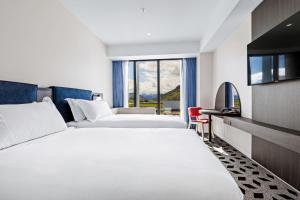 皇后镇Holiday Inn Queenstown Remarkables Park的酒店客房设有两张床和一台平面电视。