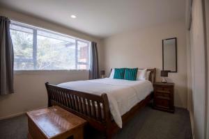 弗朗兹约瑟夫Six Kamahi Guest House & Studio Unit的一间卧室设有一张大床和一个窗户。