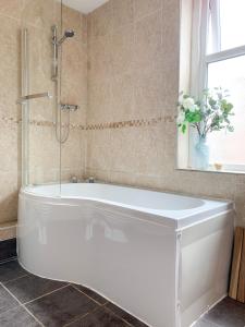 约克Riverside Lodge - Free Parking - Victorian House - Holiday Home的带窗户的浴室内的白色浴缸