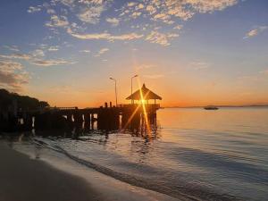 沙美岛明妮海景度假村 的水面上的一个有太阳的码头