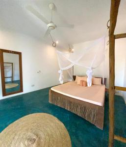 南威Siri Beach Lodge的一间卧室配有一张带吊扇和镜子的床
