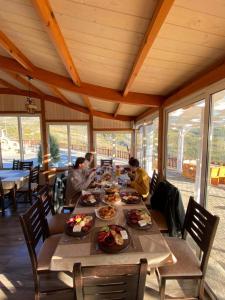 斯库台Bujtina e Muriqit的一群人坐在餐桌旁吃着食物