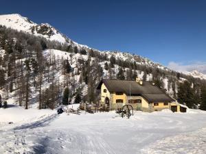 切萨纳·都灵尼斯Rifugio Baita Gimont的雪中的一个小木屋,有山
