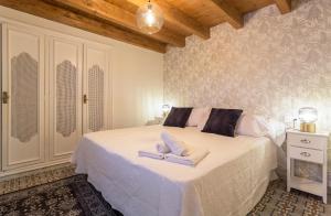 赫雷斯-德拉弗龙特拉Los Corceles Casa Palacio的一间卧室配有一张床,上面有两条毛巾