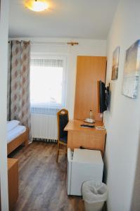 斯图加特迪斯卡夫酒店的小房间设有一张桌子和一张床