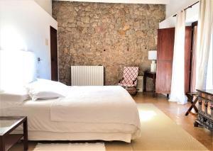 巴尔德莫萨巴尔德莫萨米拉伯酒店的卧室配有白色的床和石墙