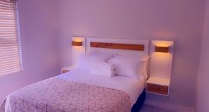 比勒陀利亚Stunning 2 Bedroom Rental at Green Creek的一间卧室配有白色的床和两盏灯