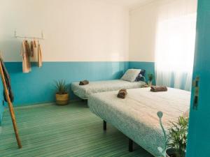 埃里塞拉Hospedium Hostel República Surf House的蓝色墙壁客房的两张床