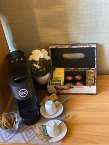 卡利亚里Home Relax的一张桌子、一个咖啡壶和一盒松饼