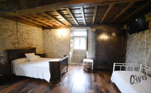 钱塔达As Casas Ribeira Sacra的一间卧室设有两张床、一个窗户和木地板。