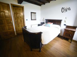钱塔达As Casas Ribeira Sacra的一间卧室设有一张大床,铺有木地板