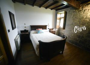 钱塔达As Casas Ribeira Sacra的一间卧室设有一张床和石墙