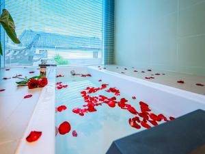 大理大理古城素色精品客栈的浴室配有浴缸,铺有红色玫瑰花瓣