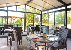 塔勒蒙露营天堂酒店的餐厅设有桌椅和窗户。