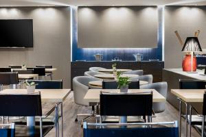 巴达霍斯巴达霍斯万豪AC酒店的用餐室配有桌椅和平面电视。