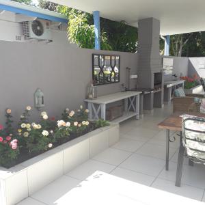 哈博罗内Aflica Apartments的一个带鲜花和桌椅的庭院
