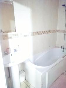 布雷得佛COSY DOUBLE ROOM CLOSE TO UNIVERSITY OF BRADFORD AND CITY CENTRE的白色的浴室设有浴缸和水槽。