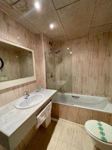 菲格拉斯Hotel & Restaurant Figueres Parc的一间带水槽、浴缸和卫生间的浴室