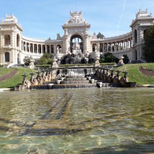 马赛LE LOGIS DU PALAIS的水面上有一个喷泉的建筑物