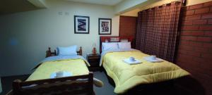 瓦拉斯Mirador Backpackers B&B的一间卧室配有两张带黄色棉被的床