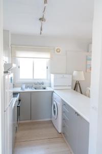 沃罗里尼Kypkeys Apartments的白色的厨房配有水槽和洗碗机