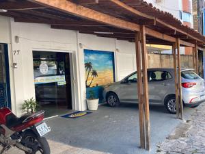 若昂佩索阿Pousada Nascer do Sol的停在一座画作建筑前面的汽车