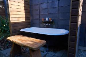 特卡波湖Designer Cabin - Lake Tekapo的浴室配有浴缸和木制长凳。