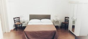 普蒂尼亚诺阿克格列恩特迪莫拉住宿加早餐旅馆的一间卧室配有一张大床和两把椅子