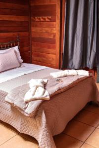 新弗里堡Chalés Paradiso的一间卧室配有两张带毛巾的床