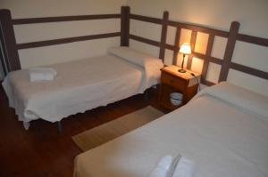 ArlanzónCasa Rural Bigotes的一间卧室设有两张床和一张桌子上的台灯。