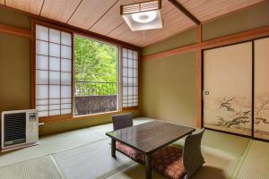 茅野Yama no Yado Meiji Onsen的一间带桌椅和窗户的用餐室