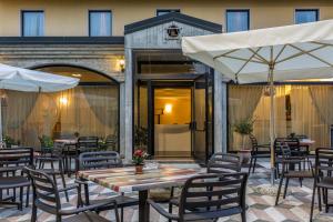 多索博诺波斯图米亚酒店的一个带桌椅和遮阳伞的户外庭院。