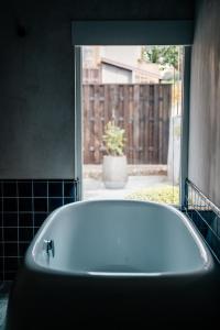 南砺Bed and Craft TATEGU-YA的带窗户的浴室内的白色浴缸