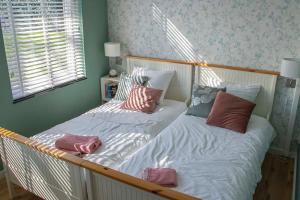 羊角村Farmhouse Lodge Giethoorn的一间卧室配有两张带枕头的床。