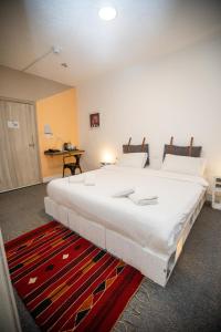 瓦迪穆萨Nomads Hotel Petra的红色地毯的房间里一张大白色的床