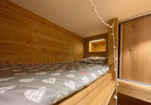 瓦卢瓦尔Les Balcons de Valloire的卧室配有木墙内的一张床