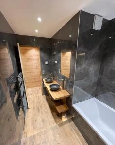 瓦卢瓦尔Les Balcons de Valloire的浴室配有盥洗盆和浴缸。