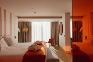 里斯本Lumen Hotel & The Lisbon Light Show的酒店客房,配有带毛巾的床